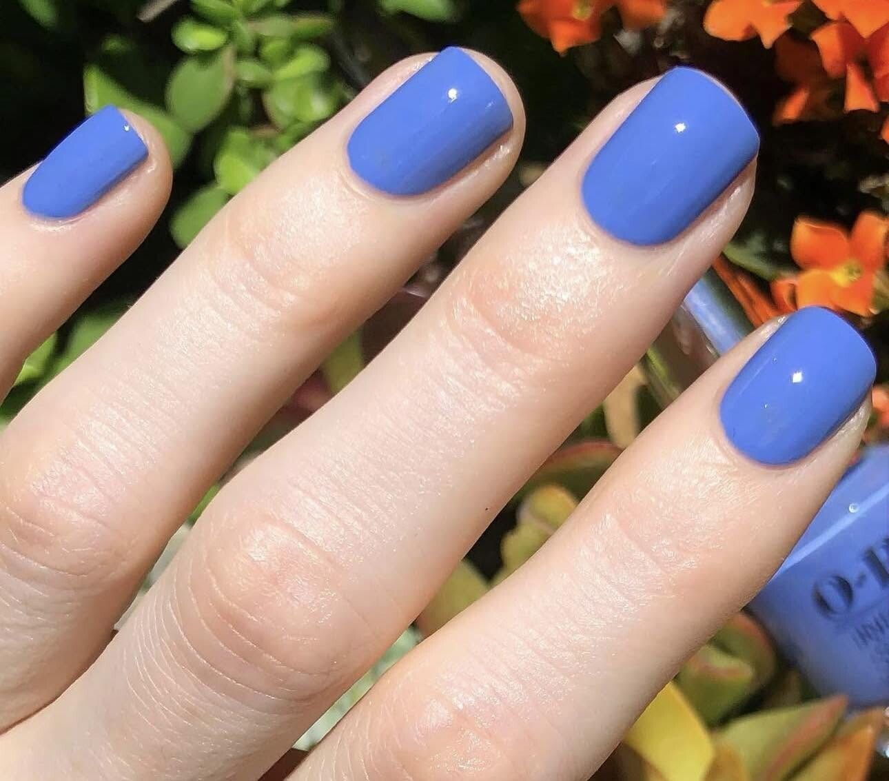 Cornflower blue gel manicure with an OPI bottle