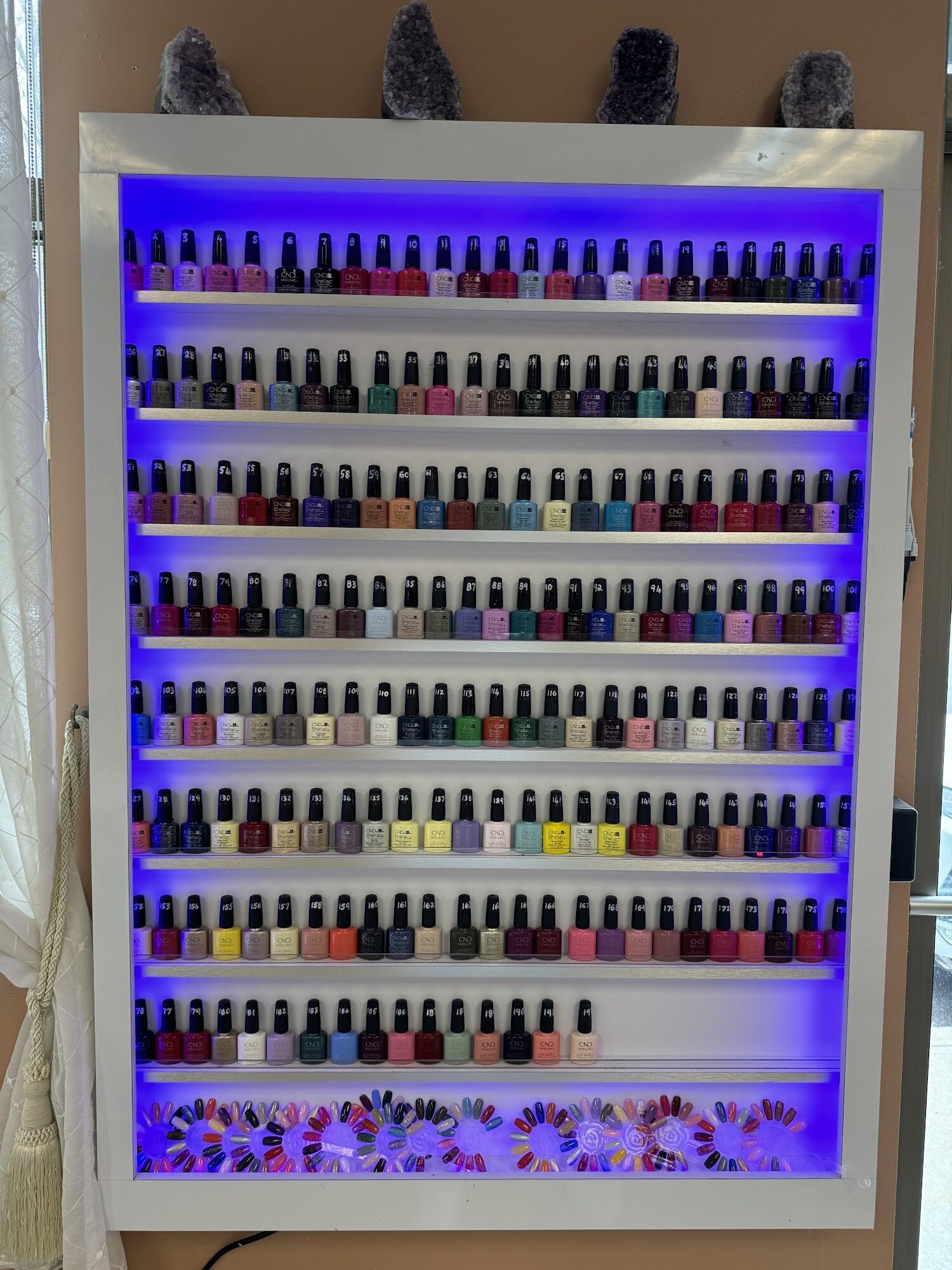 Illuminated gel polish display wall at Christine’s Nails